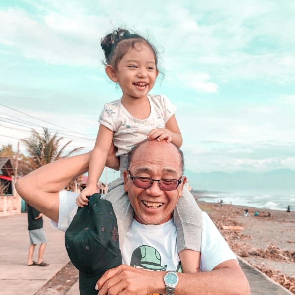 Roselani Place | Senior man holding his granddaughter on his shoulders