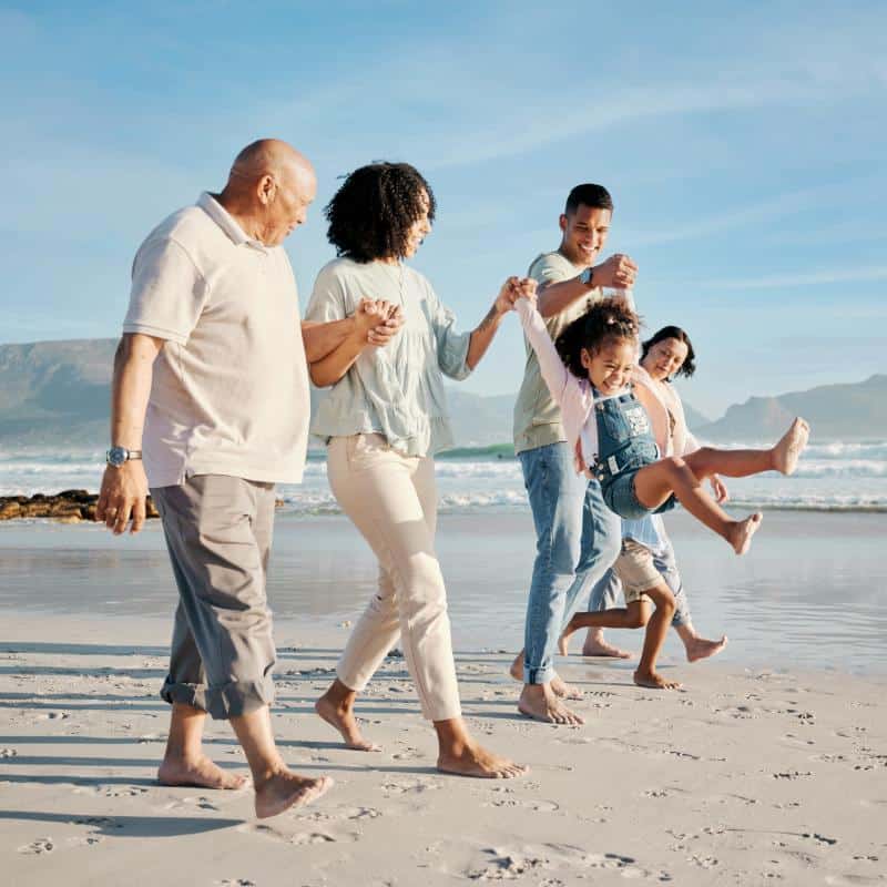 Roselani Place | Seniors couple at the beach with their family